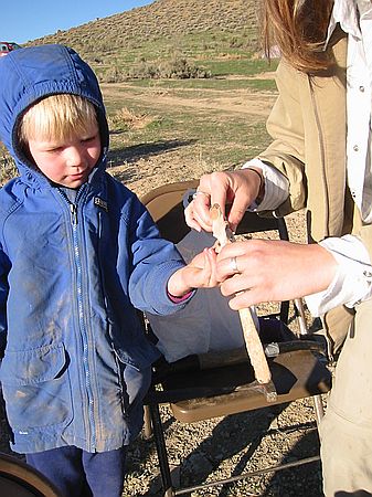 Nicole Boyle helps five year old Sam with his discovery of antelope vertebra and ribs.