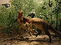 The elf is painted on the wall of the diorama, to the left of the fighting bony-headed dinosaurs. Cretaceous Creekbed diorama (Prehistoric Journey, 3rd Floor)